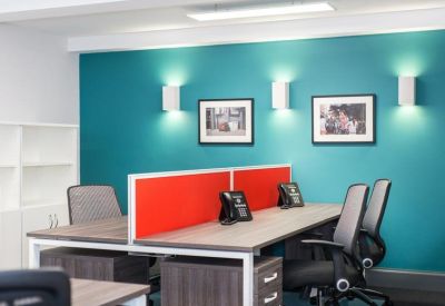 Modern workspace with a teal feature wall and integrated red desk dividers.