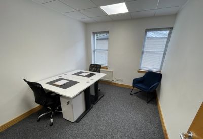 Private office suite with two white desks and a blue accent armchair.