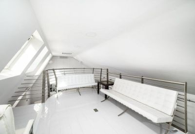 Mezzanine lounge area with white bench seating and metal railings.