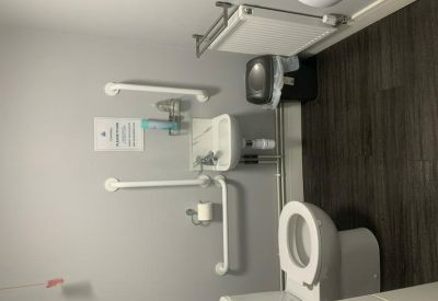Accessible restroom facility featuring grab bars and a wall-mounted sink.