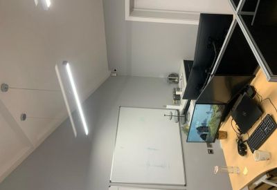 Close-up of a workstation featuring a dual monitor setup and a large white whiteboard.