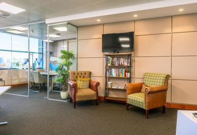 Cozy breakout area with leather armchairs and a well-stocked bookshelf.