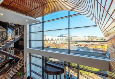 Bright atrium looking out towards a modern staircase and glass entrance.