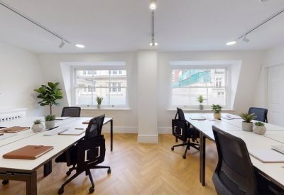 Bright workspace featuring wooden herringbone floors and large windows.