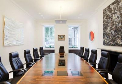 Formal boardroom featuring a long wood table, leather chairs, and large abstract wall art.
