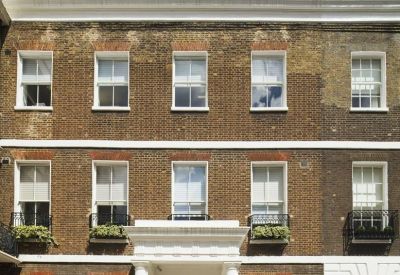 Symmetrical brick exterior facade of 22 Manchester Square with white window frames.