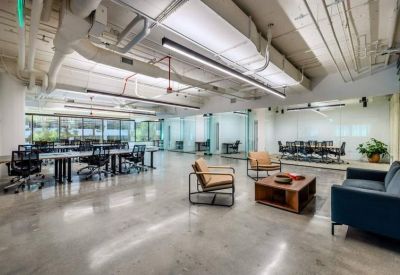 Expansive communal lounge area with polished concrete floors, modern furniture, and an open ceiling design.