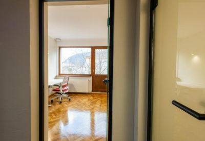 Sunlit private office space viewed through an open doorway.