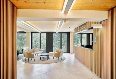 Reception area with a wooden desk and soft lounge seating under warm lighting.