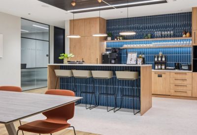 Modern office breakout area with a blue tiled breakfast bar and pendant lighting.