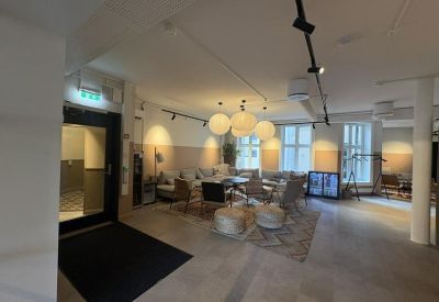 Spacious lounge area with diverse seating, globe pendant lights, and large windows.