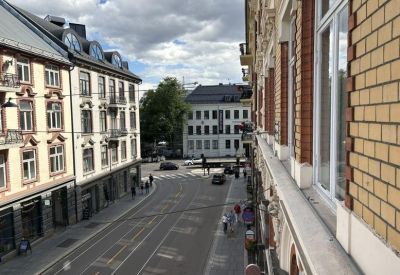 View from the balcony showing historic architecture and a tram line on a sunny day.