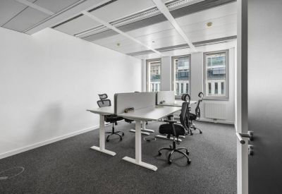 Bright, minimalist four-desk office suite with height-adjustable tables.