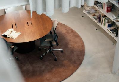 Modern office interior with round table and bookshelves at Rue van Malder in Brussels.