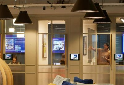 Modern lounge area with modular blue and grey seating and industrial-style pendant lighting.