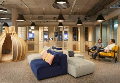 Open-plan coworking space featuring a unique wooden pod and comfortable lounge seating.