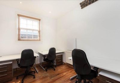 Private three-person office suite with white desks and wooden flooring.