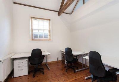 Attic-style office space with vaulted ceilings and rustic timber beams.