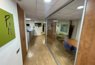 Bright glass-walled reception and corridor at 25, Carrer de Solà, Bajos.