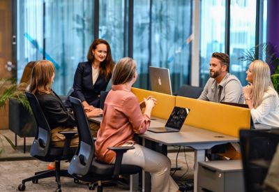 Team meeting at a round table in a collaborative office space.
