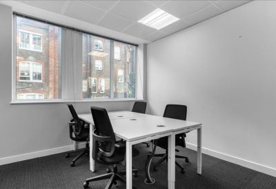 Private four-person office suite with white desks and large windows.