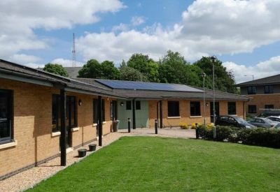 Exterior view of the brick facade and lawn at 26-28, Thorpe Wood,, with solar panels on the roof.