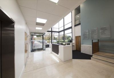 Bright, airy reception lobby with a white front desk and polished tile flooring.
