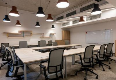 Large U-shaped meeting table with ergonomic chairs and whiteboard.