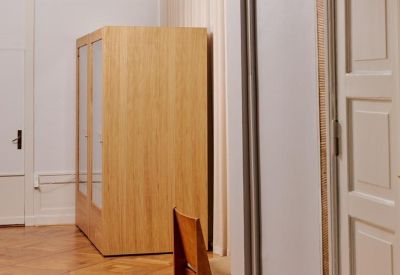 View through a doorway showing a wooden cabinet and an architectural pendant light.