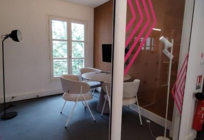 Small private meeting room with a round table and graphic wall art.