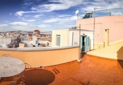 Spacious rooftop terrace with terracotta tiling and views over the city rooftops.