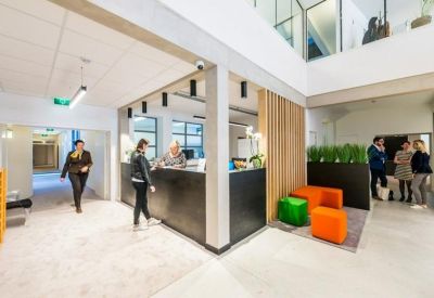 Modern reception desk with vibrant orange and green modular seating.