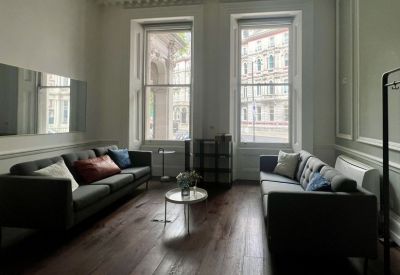 Modern lounge area with dark grey sofas and polished hardwood flooring.