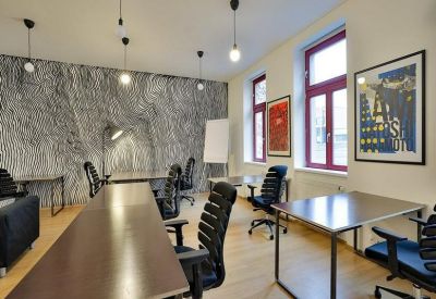 Open-plan workspace with dark chairs and textured wall decor.