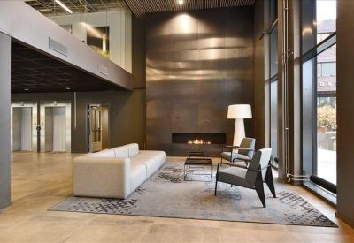 Lobby lounge area with a sleek fireplace and a large white floor lamp.