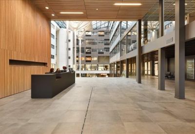 Large open-plan building lobby with a dark minimalist reception desk.