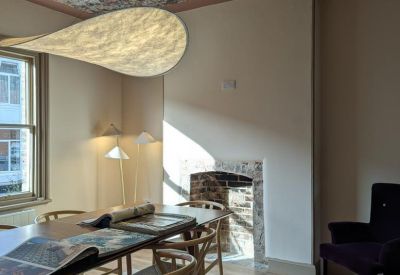 Dining room with floral ceiling and unique hanging light fixture.