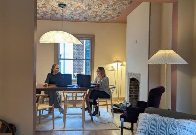 Two-person workspace with laptops and a view outside.