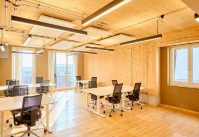 Spacious open-plan office with timber ceilings and individual white workstations.