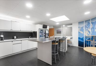 Modern communal kitchen and breakout area with a central island and mountain mural.
