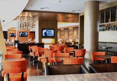 Private windowed office with a desk and black guest chairs.