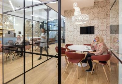 Private meeting booth with glass walls and patterned wallpaper.