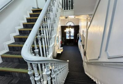 Grand internal staircase with white banisters and traditional architectural details.