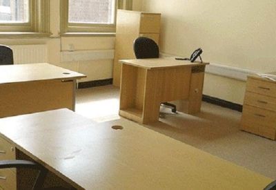 A two-person private office suite with light wood desks and filing cabinets.