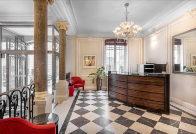 Reception area featuring a dark wood desk, checkered marble floor, and elegant chandelier.