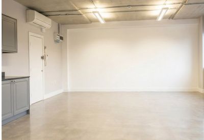 Industrial-style workspace with a raw concrete ceiling and large windows.