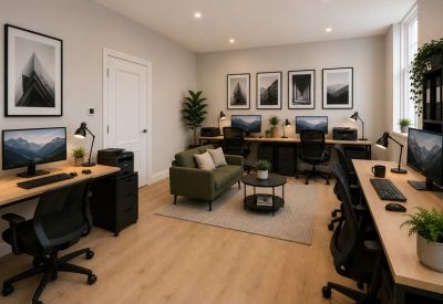 Spacious professional workspace at 2A, Leys Avenue featuring multiple desks, an olive green sofa, and wall art.