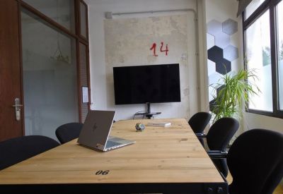Private office space with wooden desk, laptop, and large window.
