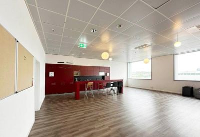 Modern breakroom and kitchen area featuring wood-style flooring and a red island counter.