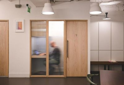 Private wood-paneled phone booth with a frosted glass door.